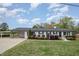 Charming one-story home with a black roof, white painted brick and a well manicured green front yard at 5121 Leesville Rd, Durham, NC 27703