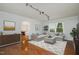 Inviting living room with a modern track lighting and a view into the dining area and kitchen at 5121 Leesville Rd, Durham, NC 27703
