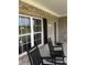 Inviting front porch with two black rocking chairs, a view of the yard, and the house number at 55 Glasgow, Rocky Mount, NC 27804