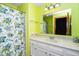 Bright, compact bathroom features a vanity with a light countertop and floral patterned shower curtain at 5932 Whitebud Dr, Raleigh, NC 27609