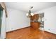 Dining area with hardwood floors and a view into the kitchen with a classic chandelier at 5932 Whitebud Dr, Raleigh, NC 27609