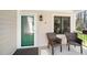 Cozy front porch with seating, a decorative door, and neutral siding, creating a welcoming entrance to the home at 5932 Whitebud Dr, Raleigh, NC 27609