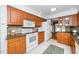 Bright kitchen with wood cabinetry, modern appliances, and an open layout, perfect for cooking and entertaining guests at 5932 Whitebud Dr, Raleigh, NC 27609