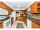Well-lit kitchen with wood cabinets, tile backsplash, and modern appliances, creating a functional and stylish cooking space at 5932 Whitebud Dr, Raleigh, NC 27609