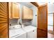 Functional laundry room with washer, dryer and built-in overhead cabinets for organized storage at 5932 Whitebud Dr, Raleigh, NC 27609