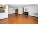 Spacious living room featuring hardwood floors, a cozy fireplace, and a view into the kitchen at 5932 Whitebud Dr, Raleigh, NC 27609