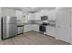 Bright kitchen features white cabinets, stainless steel appliances, granite counters and wood-look floors at 65 Crow Field St, Roxboro, NC 27574
