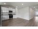 Open-concept kitchen with white cabinets, stainless steel appliances and wood-look floors at 65 Crow Field St, Roxboro, NC 27574