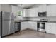 Bright kitchen features white cabinets, stainless steel appliances, granite counters and wood-look floors at 65 Crow Field St, Roxboro, NC 27574