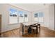 Bright dining room with wood floors, large windows, modern table and chairs, and a minimalist aesthetic at 6926 Leesville Rd, Raleigh, NC 27613