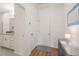 Hallway leading to a bathroom, featuring tile and hardwood flooring at 6926 Leesville Rd, Raleigh, NC 27613