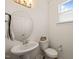 Powder room with white fixtures, an oval mirror, and a window providing natural light at 6926 Leesville Rd, Raleigh, NC 27613