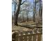 Backyard featuring a partially wooded area with mature trees and a wooden fence at 6932 Buckhorn Duncan Rd, Holly Springs, NC 27540
