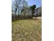 Expansive backyard featuring a wooden fence, lush trees, and a charming storage shed at 6932 Buckhorn Duncan Rd, Holly Springs, NC 27540