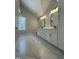 Bathroom with double vanity, sleek black fixtures, marble floors, and a window offering natural light at 6932 Buckhorn Duncan Rd, Holly Springs, NC 27540