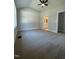 Neutral bedroom with plush carpeting, vaulted ceiling, and entry to a bathroom with a vanity at 6932 Buckhorn Duncan Rd, Holly Springs, NC 27540