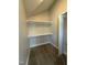 Walk-in closet features neutral carpeting, built-in shelving for optimal organization and storage at 6932 Buckhorn Duncan Rd, Holly Springs, NC 27540