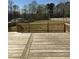 Wooden deck with a railing, overlooking a spacious backyard surrounded by trees and a fence at 6932 Buckhorn Duncan Rd, Holly Springs, NC 27540