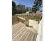 Spacious wooden deck, ideal for relaxing and enjoying the outdoor scenery, with stairs to patio at 6932 Buckhorn Duncan Rd, Holly Springs, NC 27540