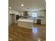 Updated kitchen with white cabinets, center island, and stainless steel appliances at 6932 Buckhorn Duncan Rd, Holly Springs, NC 27540