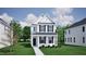 Charming two-story white home with black shutters and a well-manicured lawn on a sunny day at 728 Georgia'S Landing Pkwy # 9, Raleigh, NC 27603