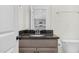 Stylish bathroom featuring a black granite countertop and wood cabinets with a door leading to another room at 75 Eltham, Rocky Mount, NC 27804