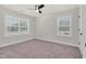 Bright bedroom featuring plush carpet, neutral walls, a ceiling fan, and two windows with lots of natural light at 75 Eltham, Rocky Mount, NC 27804