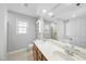Bright bathroom with double sinks, wood cabinets, a large mirror, tiled walls, and lots of lighting at 7707 Oak Marsh Dr, Raleigh, NC 27616