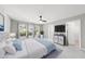 Comfortable bedroom with large windows, fan, neutral walls, and stylish furnishings with a TV at 7707 Oak Marsh Dr, Raleigh, NC 27616