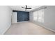 Bare bedroom featuring blue accent wall, fan, neutral carpet, and a large window at 7707 Oak Marsh Dr, Raleigh, NC 27616