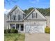 Charming two-story home boasts gray siding, black shutters, lush landscaping, and an attached two-car garage at 7707 Oak Marsh Dr, Raleigh, NC 27616