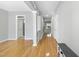 Spacious hallway featuring gleaming hardwood floors, neutral wall color, and elegant trim work throughout the home at 7707 Oak Marsh Dr, Raleigh, NC 27616