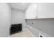 Clean laundry room with white cabinets and neutral paint at 7707 Oak Marsh Dr, Raleigh, NC 27616