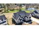 Stunning aerial view of a home with a dark roof, showcasing its landscaped yard and serene pond setting at 8005 Woodcross Way, Wake Forest, NC 27587