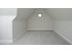 An attic room with a single window and neutral color palette, ready for customization at 8005 Woodcross Way, Wake Forest, NC 27587