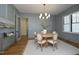 A formal dining room with wainscoting, modern lighting, and a round table sets an elegant mood at 8005 Woodcross Way, Wake Forest, NC 27587