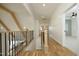 A bright hallway with wood floors, white walls, black metal railing, and natural light at 8005 Woodcross Way, Wake Forest, NC 27587