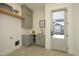 A practical laundry room with sage green cabinets, a sink, and access to the backyard enhances daily living at 8005 Woodcross Way, Wake Forest, NC 27587