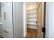 A well-organized pantry with ample shelving behind a wood door provides plenty of storage space at 8005 Woodcross Way, Wake Forest, NC 27587