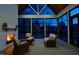 Relaxing screened-in porch features wicker furniture and a warm fireplace, perfect for evening enjoyment at 8005 Woodcross Way, Wake Forest, NC 27587