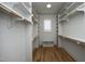 An organized walk-in closet with custom shelving, wooden rods, and hardwood flooring at 8005 Woodcross Way, Wake Forest, NC 27587