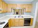 Well-lit kitchen with oak cabinetry, white countertops and view to living area at 8008 Grey Oak Dr, Raleigh, NC 27615