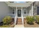 Inviting front porch with brick steps, white railing, and a decorative front door at 808 Cross Link Dr, Angier, NC 27501