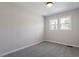 A cozy bedroom with neutral walls, carpet floors, and two windows at 8215 S Nc 119 Hwy, Mebane, NC 27302