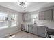 Modern kitchen with gray cabinets, stainless steel appliances, and bright natural light at 8215 S Nc 119 Hwy, Mebane, NC 27302