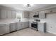 Well-lit kitchen with gray cabinets, stainless steel appliances, and quartz countertops at 8215 S Nc 119 Hwy, Mebane, NC 27302