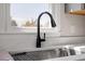 Close up of a stainless steel sink with a black faucet and a bright window at 8215 S Nc 119 Hwy, Mebane, NC 27302