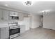 Spacious kitchen featuring gray cabinets, stainless steel appliances, and modern light fixtures at 8215 S Nc 119 Hwy, Mebane, NC 27302