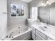 Bright bathroom featuring a soaking tub, vanity with ample storage, and large mirror at 101 Adams Peak Ln, Garner, NC 27529
