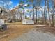 Large lot featuring a detached garage, mature trees, and a mix of gravel and grass at 1017 E Club Blvd, Durham, NC 27704